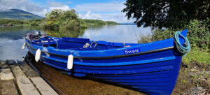 Lakes of Killarney Boat Tours traditional boat with view of mountains