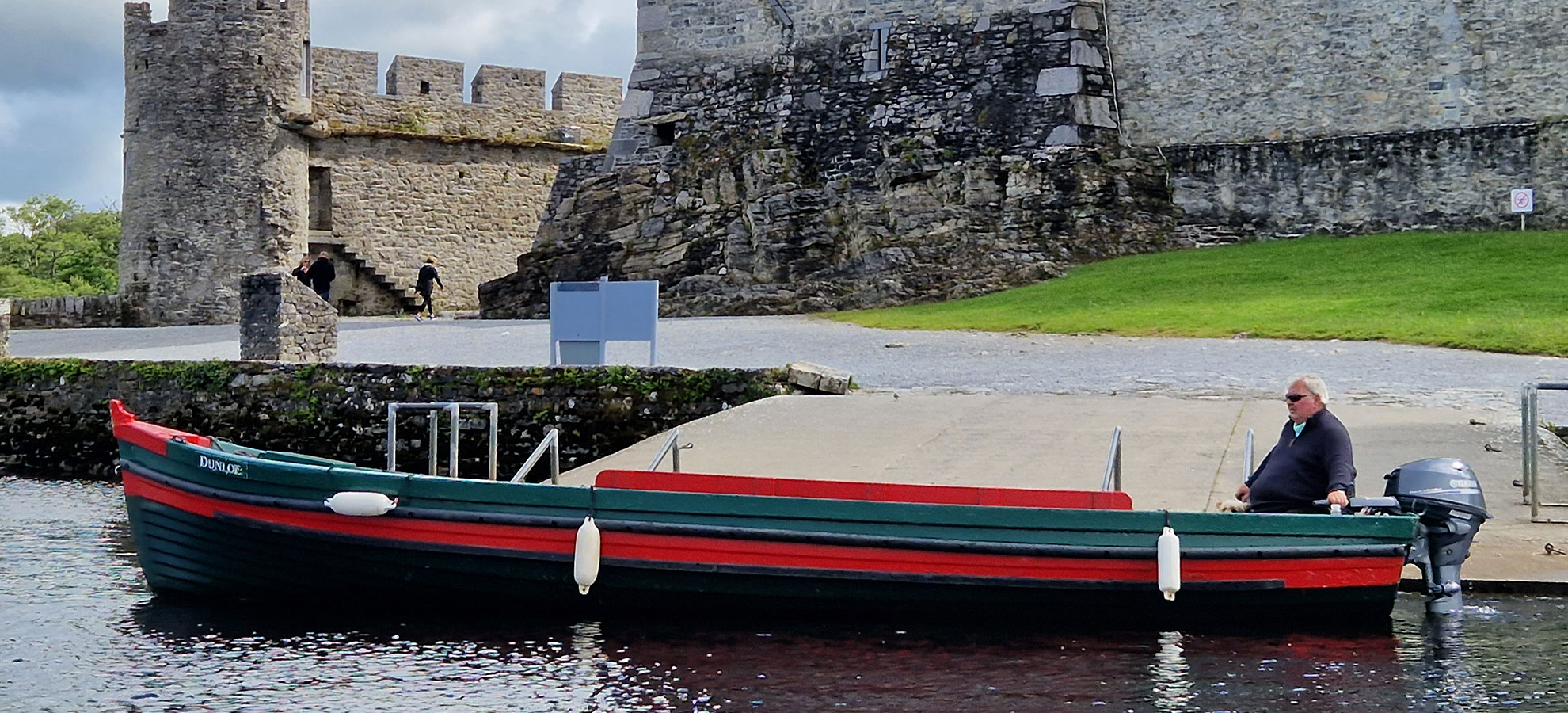 Lakes of Killarney Boat Tours traditional boat with view of Ross Castle